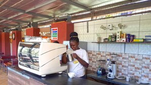 Une machine à café, une tasse et un comptoir dans un café.