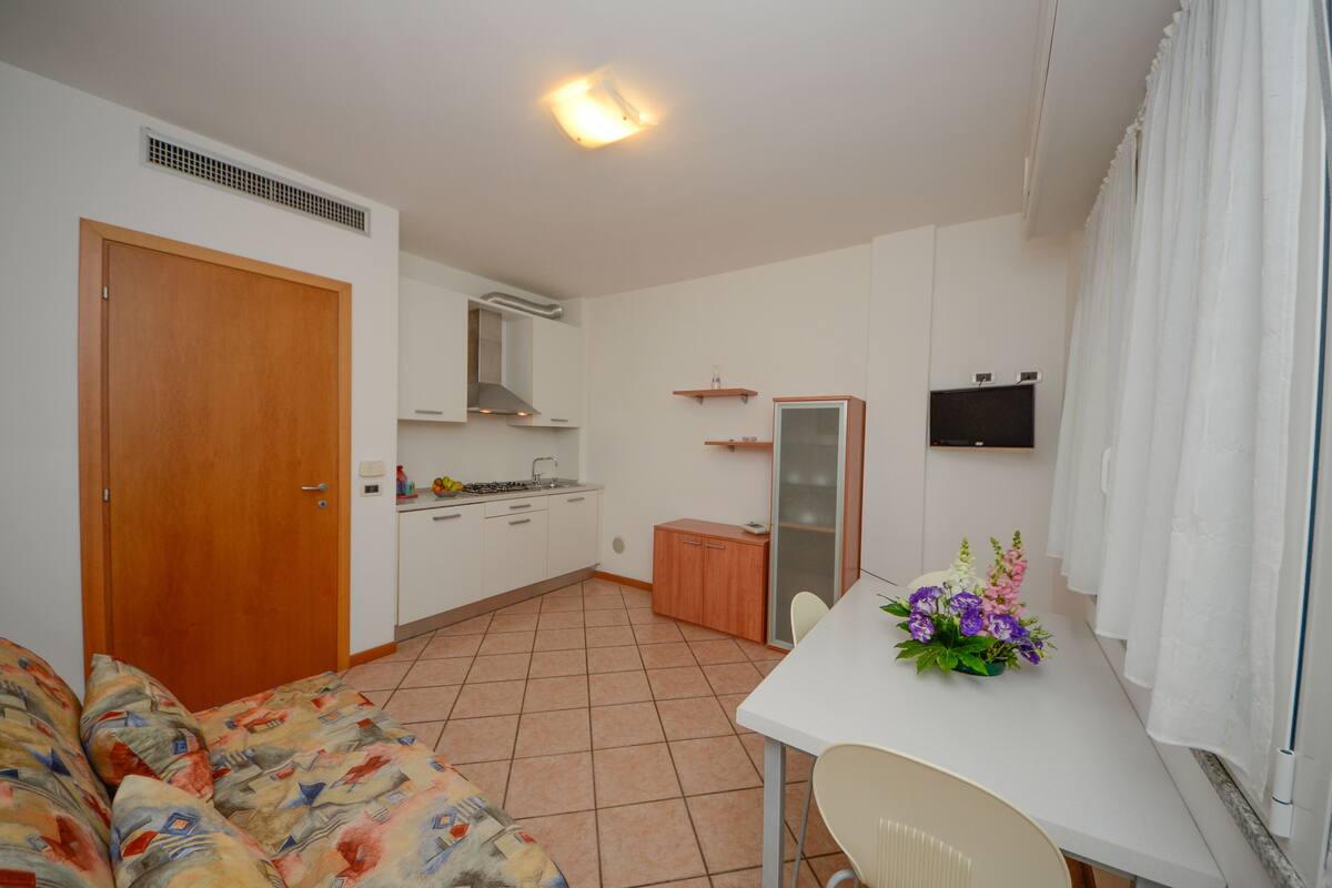 Un espacio habitable compacto con kitchenette, comedor y sofá.