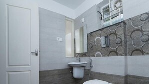 A modern bathroom with a toilet, sink, and mirror. - Ambalath Maple Leaves - Hostel (Chavakkad)