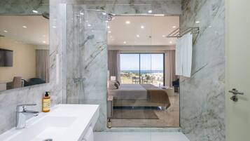 A modern bathroom with a glass-enclosed shower, a white sink, and a large mirror.