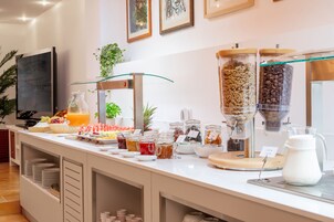 A buffet setup with various food items and a coffee station.