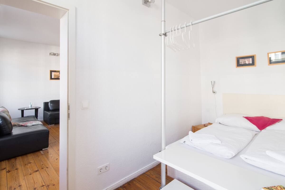 Ein Hotelzimmer mit Bett, kleinem Tisch, Stuhl und Holzboden.