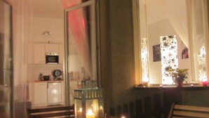 A dining area with a table and chairs, a lit candle, and a lantern. - Apartments elPilar Friedrichshain (Berlin)