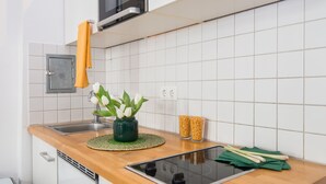 A modern kitchen with a wooden countertop, a built-in microwave, and a stainless steel sink. - Apartments elPilar Friedrichshain (Berlin)