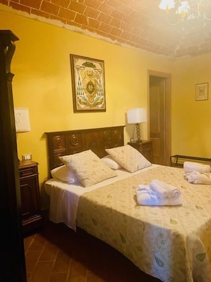 A hotel room with a bed, a nightstand, a lamp, and a framed picture on the wall. - Canonica dei Templari (Camino)