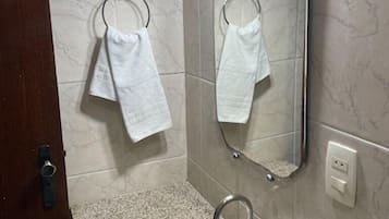 Un baño con lavamanos, dos toalleros, un espejo y una puerta.