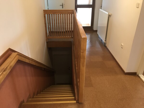 A wooden staircase with a handrail leading to a landing.
