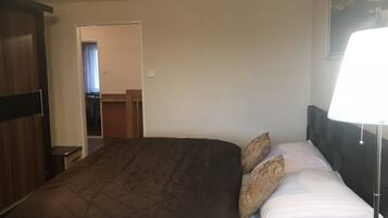 Een hotelkamer met een groot bed, een bedlampje en een deur naar een badkamer.