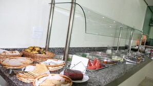 A buffet with various food items and baskets on a granite countertop. - Hotel Soldera Inn (Sertaozinho)