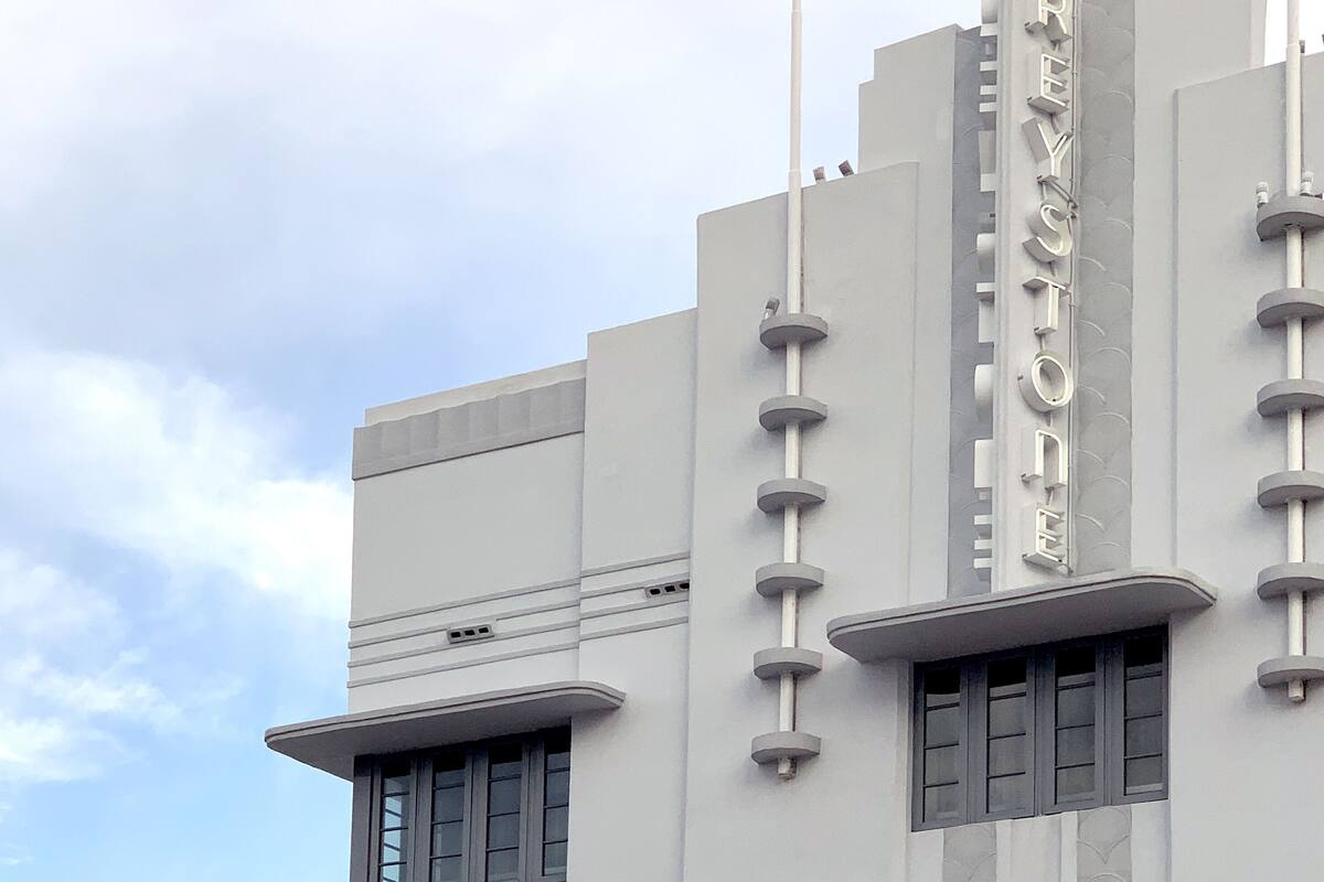 A building with a prominent 'GREYSTONE' sign, featuring a modern architectural style with geometric shapes and a flat facade.