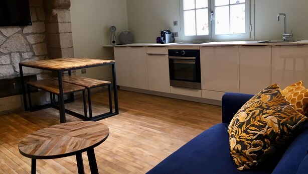 Une cuisine moderne avec un mur en pierre, des meubles en bois et une grande fenêtre.