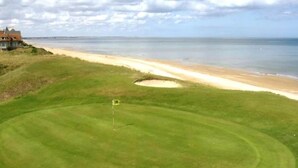 A golf course with a sand bunker and a flagstick. - Apartment in France with Balcony or Terrace (Cabourg)