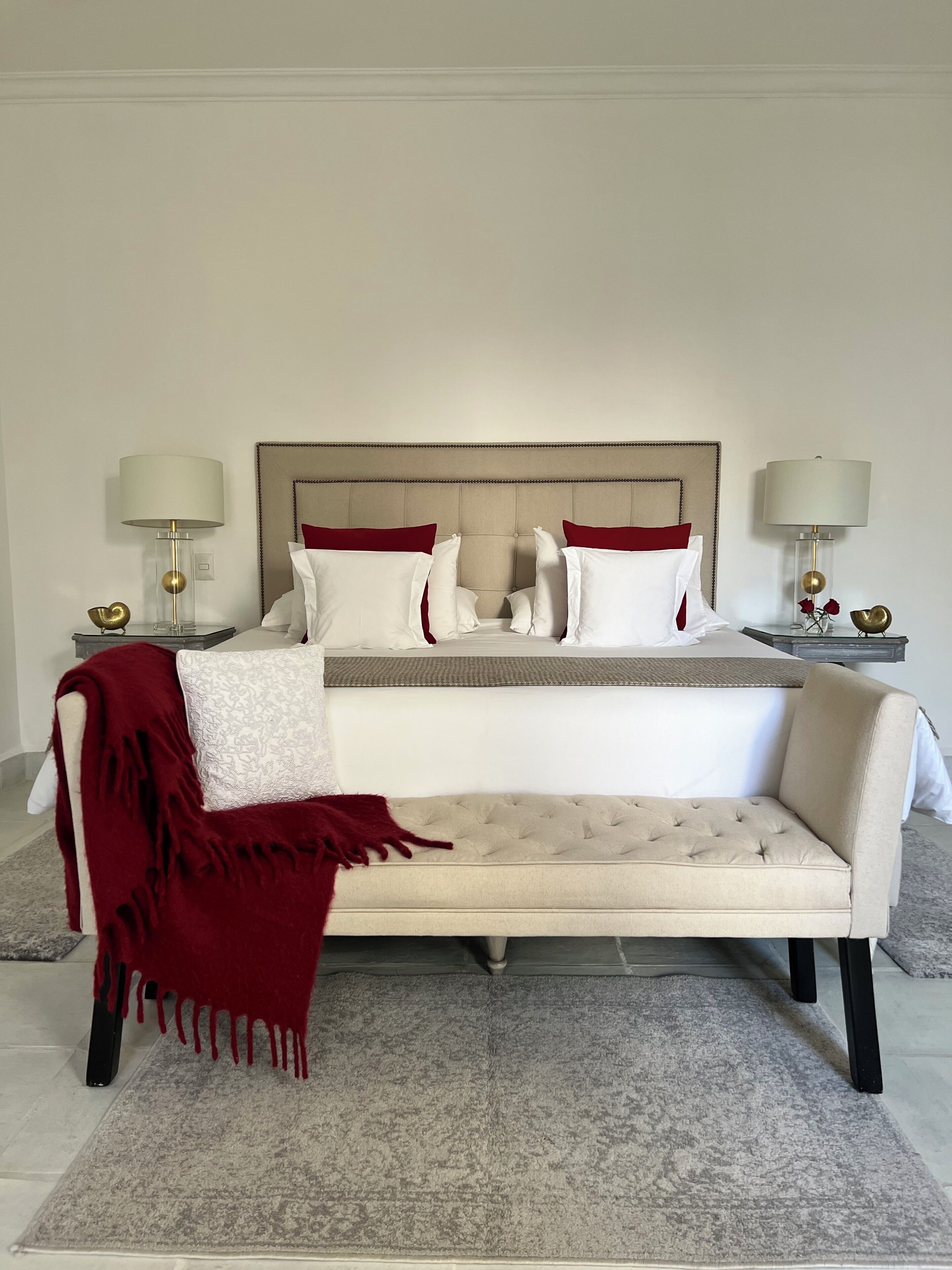 Une chambre à coucher comprenant un lit, un canapé, deux tables de chevet et des lampes.