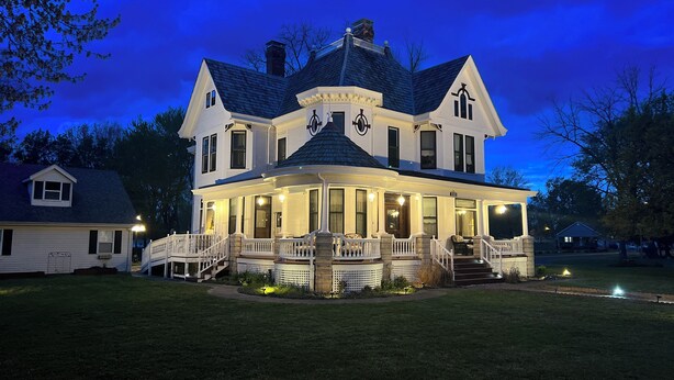 A large, two-story house with a wrap-around porch and a central tower. - The Conner House B&B (Prairie du Rocher)
