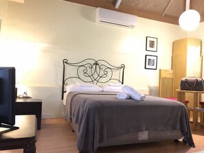Un lit bien fait, avec une tête de lit, une table de chevet avec une lampe et une chaise.