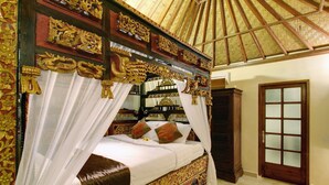Ein Bett mit Baldachin und verzierten, goldenen Schnitzereien, darüber ein Spiegel.