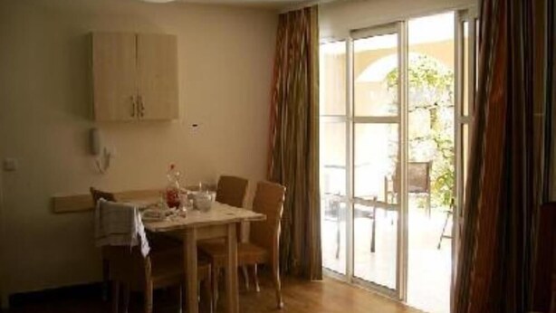 A dining area with a table and chairs, a wooden cabinet, and a sliding glass door leading to an outdoor area. - Flat - 2 rooms - 5 persons (Saint-Raphaël)