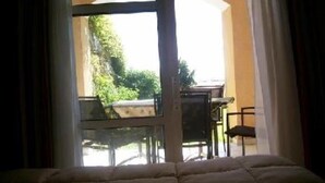 A room with a bed, a window, and a view of an outdoor patio area. - Flat - 2 rooms - 5 persons (Saint-Raphaël)