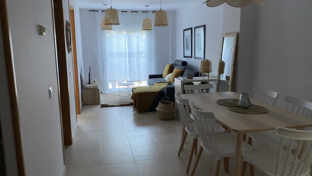 Un salon moderne avec un coin repas, comprenant un canapé, une table basse et une table à manger avec des chaises.