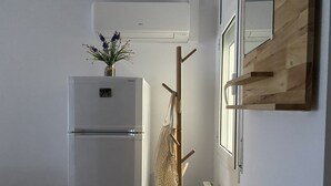 Une cuisine avec un réfrigérateur blanc, un étendoir à linge en bois et un radiateur.
