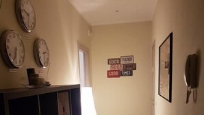 Un couloir orné d’horloges, un mur couvert d’enseignes et un téléphone.