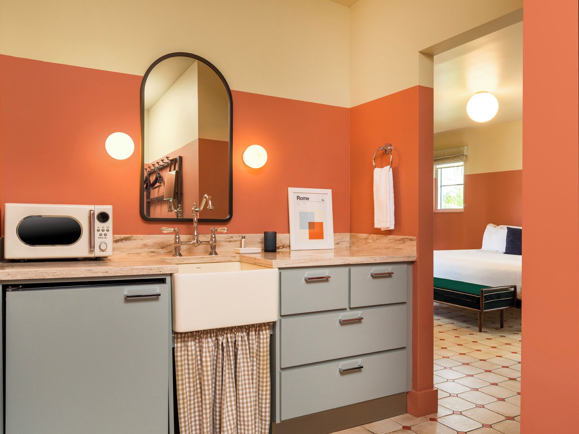 Une salle de bain d’hôtel équipée d’un lavabo, d’un miroir, d’un porte-serviettes et d’un tableau encadré au mur.