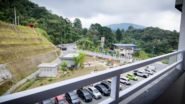 A parking area with cars, a small building, and a playground. - Cameron Highlands (Cameron Jaya) (Cameron Highlands)