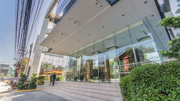 A modern building with a glass facade and a staircase leading to the entrance. - Joseph's Place @ Avenir Condo w/ NETFLIX (Cebu City)