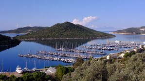 A marina with numerous boats docked, surrounded by hills and clear skies. - Villa Mavi Manzara / Luxury, secluded private villa (Kas)