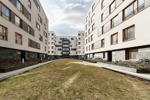 Un moderno complejo de apartamentos con un patio central, varios balcones y un diseño limpio y contemporáneo.