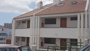 A two-story building with a tiled roof, multiple windows, and a gated entrance. - Los Cristianos Apartment Nirvana Tenerife South (Los Cristianos)