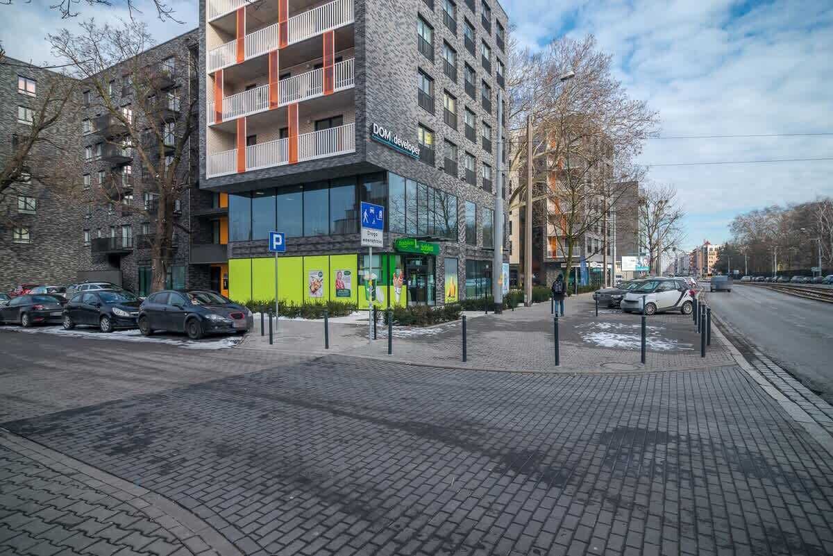En moderne bygning med parkeringsplads, en McDonald's restaurant og en tydelig indgang.