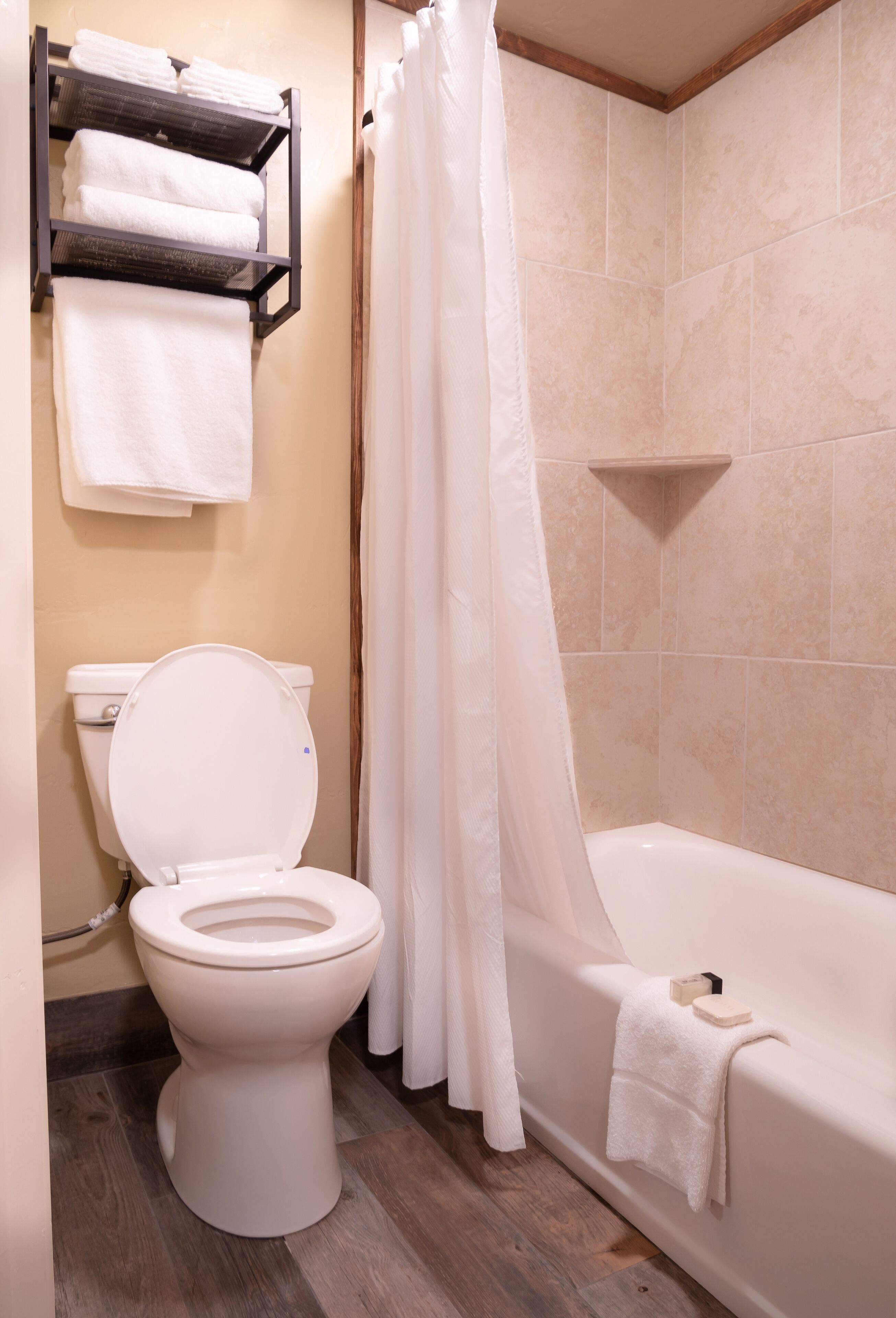 A bathroom with a toilet, a bathtub, and a shower curtain.