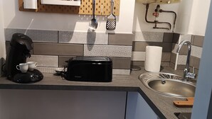 A kitchen with a coffee maker, toaster, and sink.