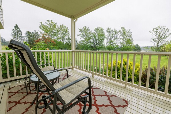 A covered outdoor seating area with a view of a green landscape.
