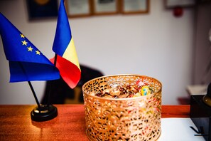 A table with a decorative glass container and two flags.