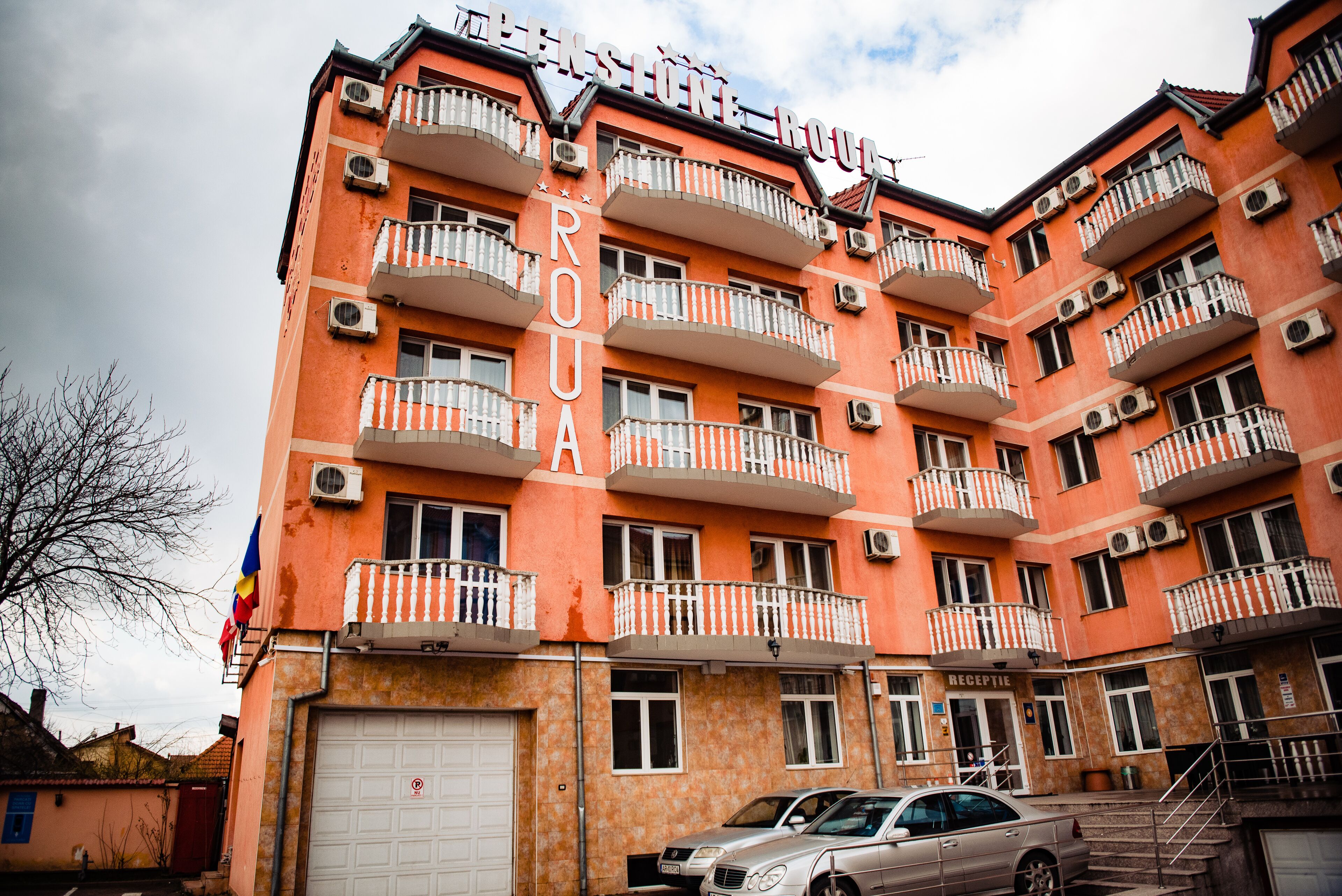 Ein mehrstöckiges Gebäude mit Balkonen, einer Rezeption und einer Garage.