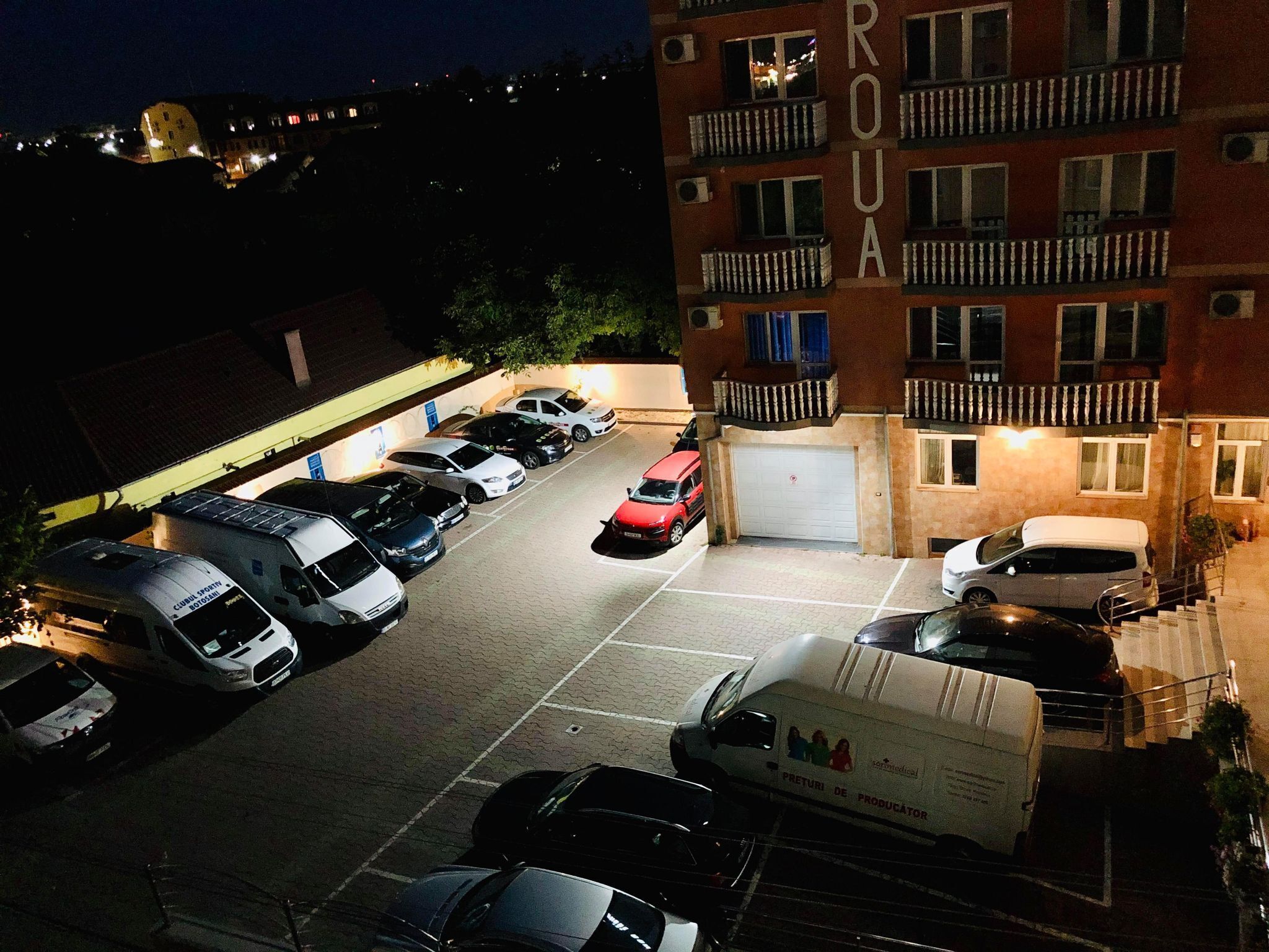 A parking lot with several cars and a delivery truck.