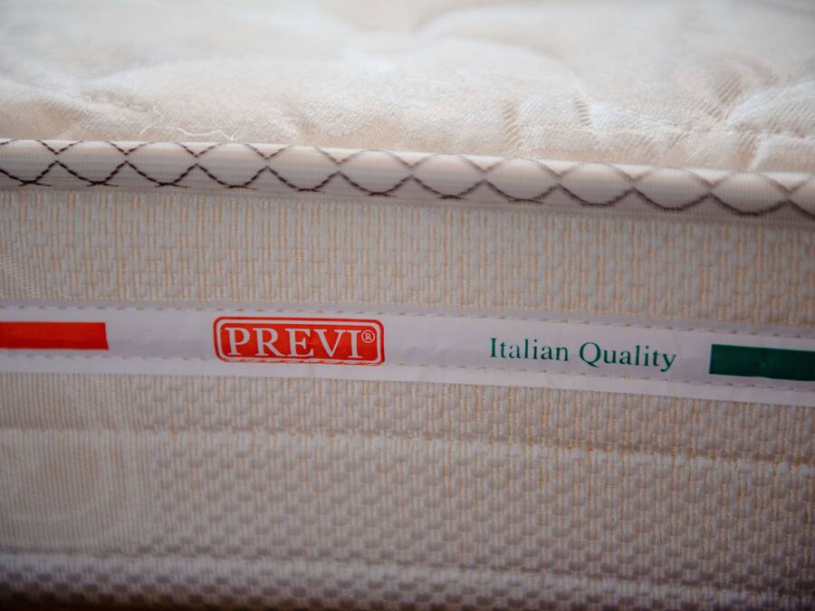 A mattress with a label indicating "PREV" and "Italian Quality".