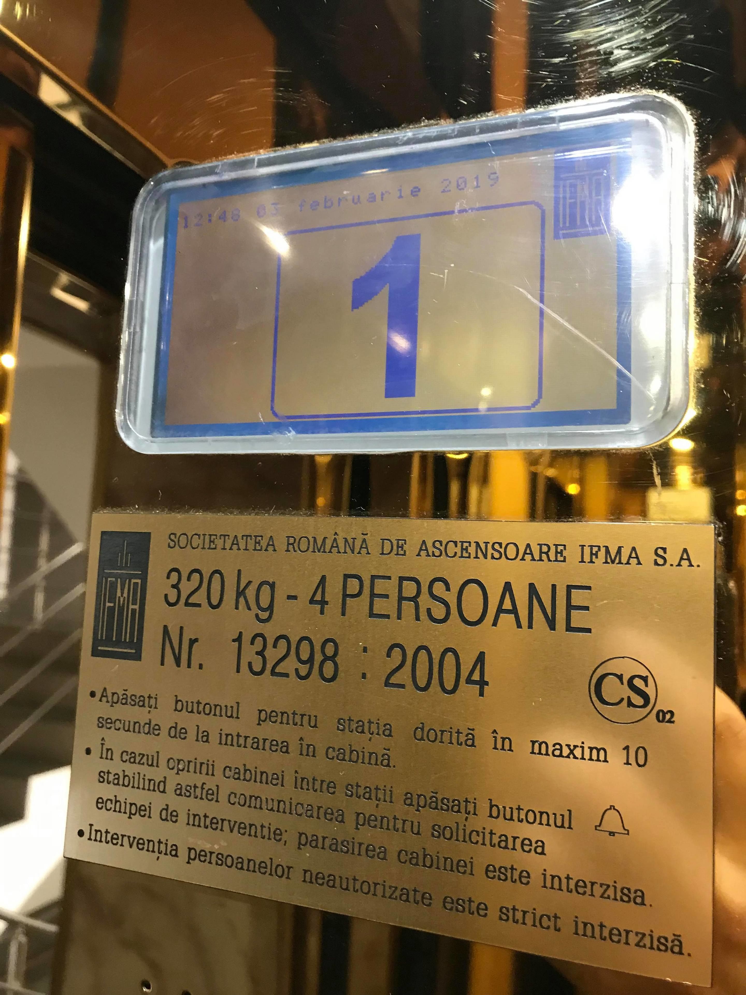 A sign with a blue number '1' and text in Romanian, indicating a specific room or section.