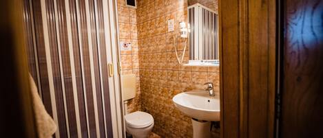 A bathroom with a striped shower curtain, a white sink, and a mirror above it.