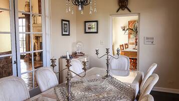 A dining area with a patterned tablecloth, ornate candelabras, and a chandelier.