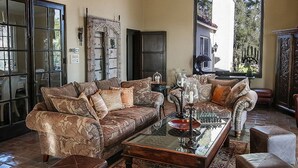 A spacious living room with a large window, a fireplace, and a coffee table.