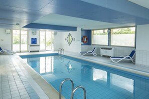 An indoor swimming pool with clear blue water, a lifebuoy, and lounge chairs. - Apartment in Bergheim near Picturesque Town (Bergheim)