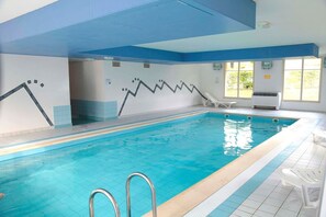 An indoor swimming pool with clear water, a diving board, and a sunlit area with a window. - Apartment in Bergheim near Picturesque Town (Bergheim)