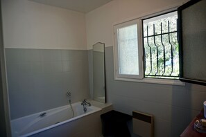 Een bad/douchecombinatie, een haardroger, een bidet, handdoeken