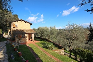 A stone house with a tiled roof, a paved pathway, and a garden with various plants and flowers. - House & Dependance for 6 People, Wonderful place, Garden, Wifi, Tuscany (Corsanico-bargecchia)