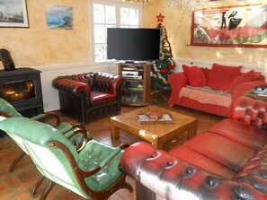 A living room with a fireplace, leather sofas, a coffee table, and a television.
