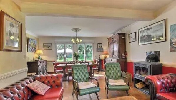 Ein Wohnzimmer mit Ledersofas, einem Essbereich und einem Kamin.