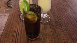 A bar area with drinks, a laptop, and a speaker. - El Currican (Guayacanes)
